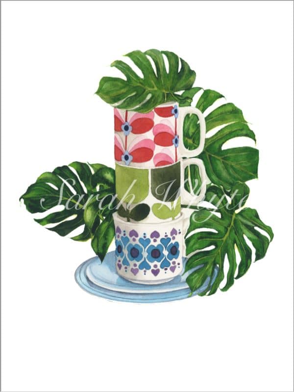 A stack of three colorful floral vintage mugs on a turquoise saucer, set against several green leaves of Monstera Deliciosa, against a white background