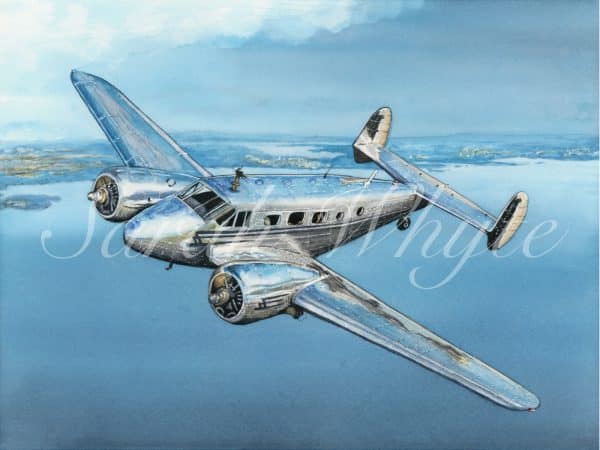 A silver Twin Beech aircraft in flight, reflecting the blues and greys of the harbour below